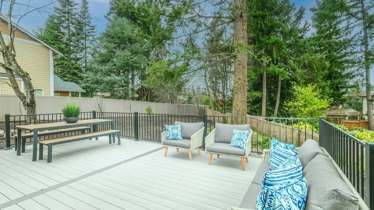 Light gray deck with outdoor seating and a dining table
