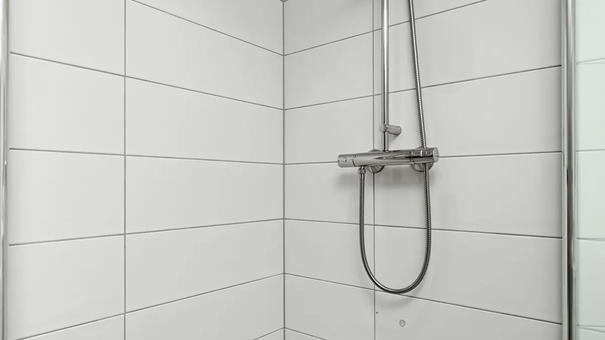 Walk-in shower with large white wall tiles